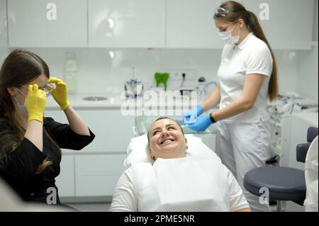 Positiv entzückte Frau, die beim Check-up im Kabinett ihres Zahnarztes sitzt. Hochwertiges Foto Stockfoto