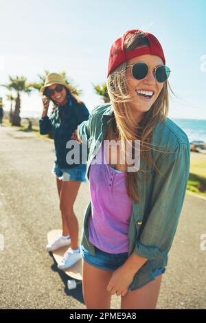 Ich fahre nur meinen Freund. Zwei Freunde, die mit einem Skateboard auf der Promenade rumhängen. Stockfoto