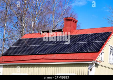 Sonnenkollektoren auf dem Dach eines Vorstadthauses an einem wunderschönen, sonnigen Tag im Frühling. Stockfoto