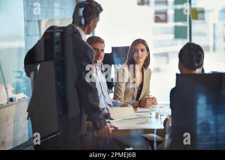Besprechung, um wichtige geschäftliche Angelegenheiten zu besprechen. Ein Team von Kollegen, das ein Meeting in einem Büro abhält. Stockfoto
