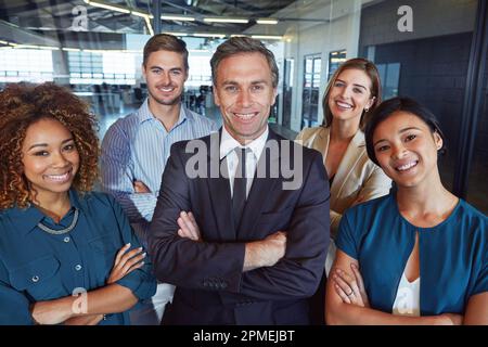 Wir setzen uns gemeinsam für den Unternehmenserfolg ein. Porträt eines Teams von Profis, die in einem Büro zusammenstehen. Stockfoto