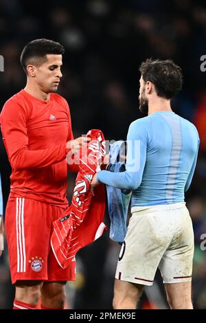 England, Manchester - 11. April 2023 - Bernardo Silva aus Manchester City und Joao Cancelo aus Bayern München tauschen während der UEFA Champions Le Trikots aus Stockfoto