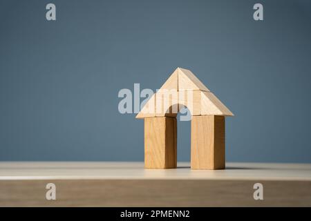 Haus mit Bogentür mit Holzblöcken. Wohnungskauf und -Verkauf. Design- und Architekturdienstleistungen. Sachversicherung. Überprüfung des Immobilienmarktes. Stockfoto