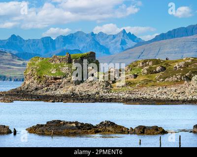 Dunscaith (Dun Scaich) Burgruinen in Tokavaig mit Black Cuillin Mountain Ridge in der Ferne, Isle of Skye, Schottland, Großbritannien. Stockfoto