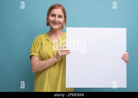 Eine Frau mittleren Alters, die ein Plakat zur Information hält Stockfoto