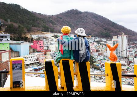 Koreanische Reisende machen Fotos mit einer kleinen Prinzfigur und einer Fuchsstatue mit einer Landschaft aus dem Kulturdorf Gamcheon oder Santorini von Pusan Stockfoto