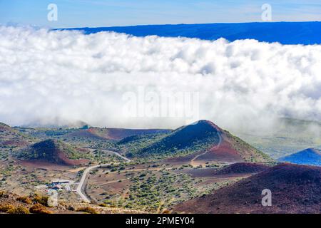 Aus der Vogelperspektive sehen Sie die vulkanische Landschaft von Mauna Kea, die eine Mischung aus zerklüfteten braunen Hügeln und Tälern darstellt, die aus vergangenen vulkanischen Aktivitäten entstanden sind und mit diesen bedeckt sind Stockfoto