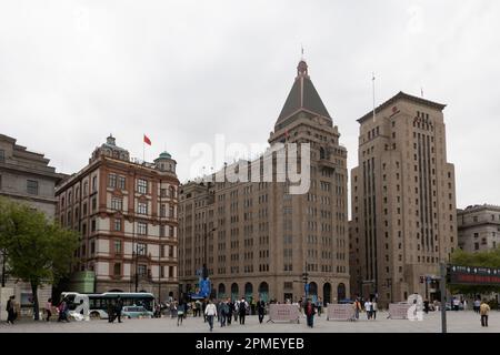SHANGHAI, CHINA - 13. APRIL 2023 - Chinesische und brasilianische Nationalflaggen flattern im Wind über dem Haupteingang des Peace Hotels an der Nanjing Road Stockfoto