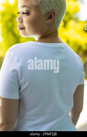 Nahaufnahme einer birassischen Frau, die ein weißes T-Shirt über dem Swimmingpool im Garten trägt Stockfoto