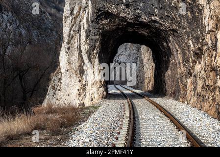 Alte Eisenbahn durch kurze Tunnel in malerischer ländlicher Landschaft Stockfoto