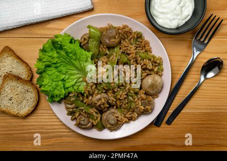 Risoni Pasta - Linsen und Kichererbsen mit Pilzen, knusprig gebratene Zucchini und Salat. Draufsicht Stockfoto