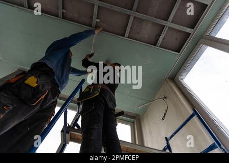 Drywall Installers. Men holding a gypsum board figured cut Stockfoto