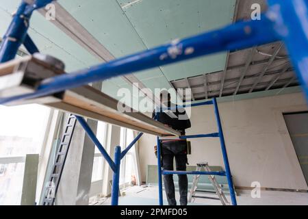 Drywall Installers. Men holding a gypsum board figured cut Stockfoto