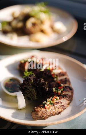 Leckeres gebackenes Schweinefilet und Kartoffelbeilagen auf der Sommerterrasse. Abendessen im Freien Stockfoto