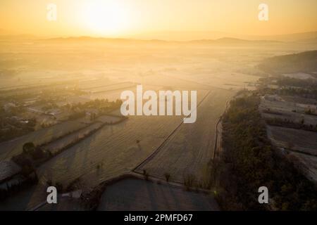 Frankreich, Vaucluse, Naturpark Luberon, Sonnenaufgang über der Ebene am Fuße des Dorfes Gordes (Luftaufnahme) Stockfoto