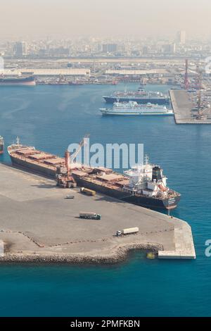 Jeddah, Saudi-Arabien - 22. Dezember 2019: Entladen eines Massengutschiffs in Jeddah Islamic Seaport an einem sonnigen Tag, vertikales Foto Stockfoto