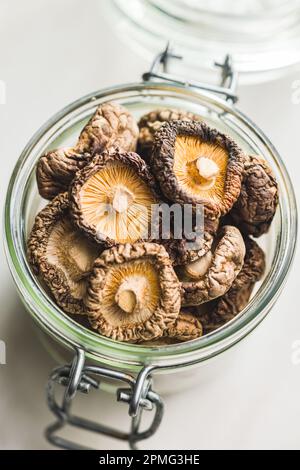 Getrocknete Shiitake-Pilze im Glas auf dem Küchentisch. Stockfoto