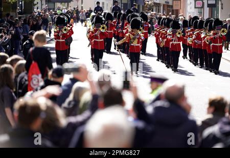 Die Band der Walisischen Garde führt Mitglieder der irischen Garde an, die die High Street hochmarschieren, um die Wachablösung im Schloss Windsor zu feiern. Foto: Donnerstag, 13. April 2023. Stockfoto
