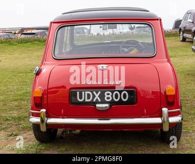 April 2023: Klassischer roter Mini Cooper bei der Pageant of Motoring on the Rasen im Weston super Mare in North Somerset, Großbritannien. Stockfoto