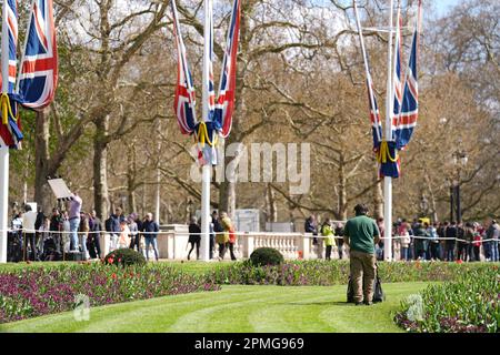 Ein Mann schneidet vor dem Buckingham Palace, London, Gras. Im gesamten Vereinigten Königreich laufen Vorbereitungen für die Krönung am 6. Mai. Foto: Donnerstag, 13. April 2023. Stockfoto