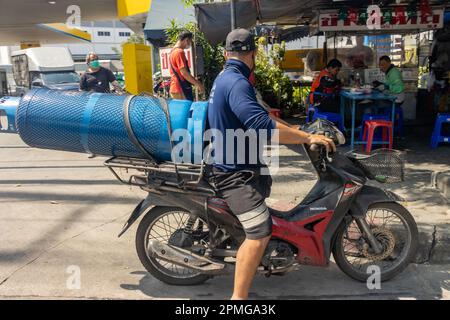 SAMUT PRAKAN, THAILAND, JANUAR 21 2023, Ein Mann transportiert eine große Gasflasche auf einem Motorrad Stockfoto