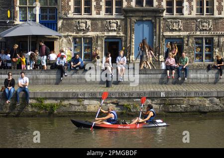 Touristen in canoo in Graslei an der Leie mit entspannenden Menschen in Gent, Flandern, Belgien Stockfoto