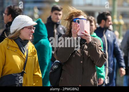 London, Großbritannien. 12. April 2023. Eine Frau auf der Westminster Bridge in London fotografiert Big Ben mit ihrem Handy. Kredit: SOPA Images Limited/Alamy Live News Stockfoto