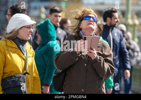 London, Großbritannien. 12. April 2023. Eine Frau auf der Westminster Bridge in London mit einem Handy. Kredit: SOPA Images Limited/Alamy Live News Stockfoto