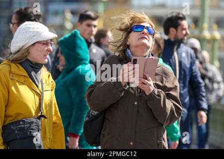 London, Großbritannien. 12. April 2023. Eine Frau auf der Westminster Bridge in London mit einem Handy. (Foto: Steve Taylor/SOPA Images/Sipa USA) Guthaben: SIPA USA/Alamy Live News Stockfoto
