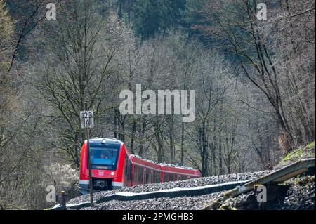 Kyllburg, Deutschland. 13. April 2023. Ein Zug der Klasse VT 620 fährt auf einer besonderen Fahrt über eine Brücke über den Kyll zwischen Kyllburg und St. Thomas, der im Juli 2021 von der Flut zerstört wurde. Die Premiere war der Beginn der Zugfahrt auf dem Abschnitt der Eifel-Linie zwischen Kyllburg und Gerolstein. Die Züge der Eifel-Linie sollen ab April 17 wieder in Betrieb genommen werden. Dies bedeutet, dass ein weiterer Abschnitt der stark beschädigten Strecke wieder an das Schienennetz angeschlossen wird. Kredit: Harald Tittel/dpa/Alamy Live News Stockfoto