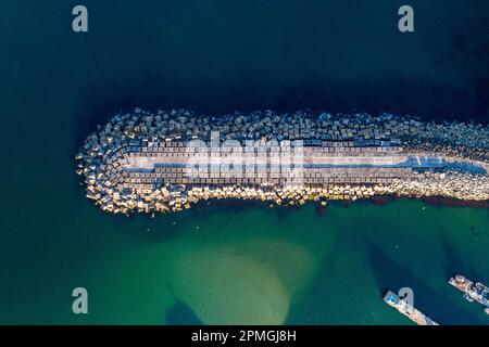 Zenithale Luftaufnahme eines Wellenbrechers im Hafen Stockfoto