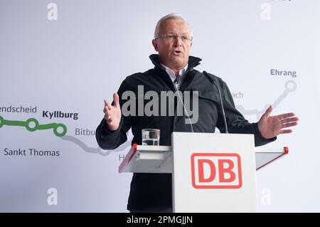 Gerolstein, Deutschland. 13. April 2023. Achim Hallerbach, Vorsitzender des Zweckverbands Schienenpersonennahverkehr Nord, spricht am Bahnhof Gerolstein, nachdem er auf einer Sonderreise von Kyllburg nach Gerolstein in einem erstklassigen Eisenbahnwaggon gefahren ist. Die Premiere war der Beginn der Zugfahrt auf dem Abschnitt der Eifel-Linie zwischen Kyllburg und Gerolstein. Ab April 17 sollen die Züge wieder auf der Eifel-Linie verkehren. Dies bedeutet, dass ein weiterer Abschnitt der stark beschädigten Strecke wieder an das Schienennetz angeschlossen wird. Kredit: Harald Tittel/dpa/Alamy Live News Stockfoto