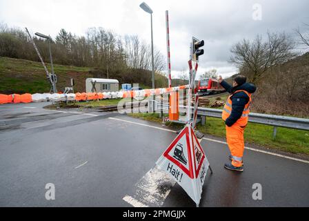 Kyllburg, Deutschland. 13. April 2023. Ein Sicherheitsangestellter der Deutschen Bahn winkt an einer Kreuzung einer Premiere. Die Premiere war der Beginn der Zugverbindung auf dem Abschnitt der Eifel-Linie zwischen Kyllburg und Gerolstein. Die Züge der Eifel-Linie sollen am 17. April wieder in Betrieb genommen werden. Dies bedeutet, dass ein weiterer Abschnitt der stark beschädigten Strecke wieder an das Schienennetz angeschlossen wird. Der Ministerpräsident von Rheinland-Pfalz, Dreyer (SPD), hat die Strecke symbolisch mit einer Fahrt mit einem Spezialzug in Betrieb genommen. Kredit: Harald Tittel/dpa/Alamy Live News Stockfoto