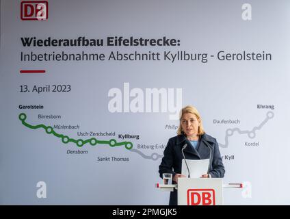 Gerolstein, Deutschland. 13. April 2023. Evelyn Palla, Vorstandsmitglied der Deutschen Bahn Regional Transport, spricht am Bahnhof Gerolstein, nachdem sie auf einer Sonderreise von Kyllburg nach Gerolstein in einem erstklassigen Eisenbahnwaggon gefahren ist. Die Premiere war der Beginn der Zugfahrt auf dem Abschnitt der Eifel-Linie zwischen Kyllburg und Gerolstein. Ab April 17 sollen die Züge wieder auf der Eifel-Linie verkehren. Dies bedeutet, dass ein weiterer Abschnitt der stark beschädigten Strecke wieder an das Schienennetz angeschlossen wird. Kredit: Harald Tittel/dpa/Alamy Live News Stockfoto