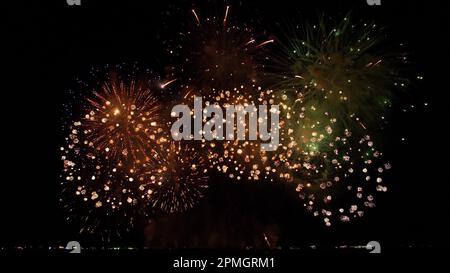 Abstrakter, farbenfroher Hintergrund für echtes Feuerwerk mit großem, leuchtendem Feuerwerk und Bokeh-Lichtern am Nachthimmel. Stockfoto