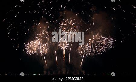 Abstrakter, farbenfroher Hintergrund für echtes Feuerwerk mit großem, leuchtendem Feuerwerk und Bokeh-Lichtern am Nachthimmel. Stockfoto