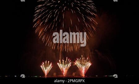 Abstrakter, farbenfroher Hintergrund für echtes Feuerwerk mit großem, leuchtendem Feuerwerk und Bokeh-Lichtern am Nachthimmel. Stockfoto