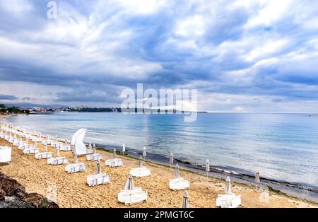 Liegestühle und Sonnenschirme stehen an einem einsamen Strand Stockfoto