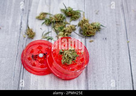 Medizinische Marihuana-Knospen und eine rote Mühle Stockfoto