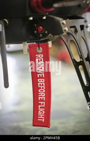 An der Drohne hing ein Warnband oder „rote Flagge“, das die Piloten und das Bodenpersonal daran erinnert, sich vor dem Flug zu entfernen. Turin, Italien - April 2023 Stockfoto