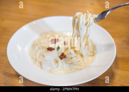 Spaghetti Carbonara serviert auf weißem Teller. Weichzeichner Stockfoto