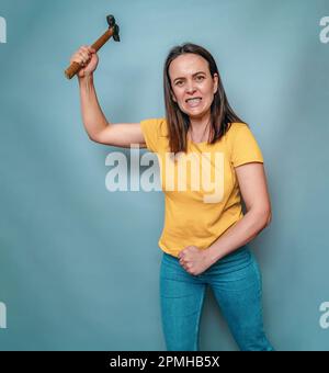 Die Frau hält sich in den Händen und schwingt den Schirm. Weibliche Wut Stockfoto