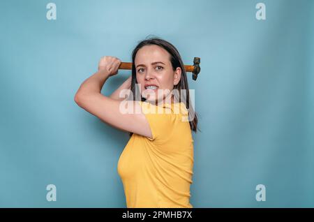 Die Frau hält sich in den Händen und schwingt den Schirm. Weibliche Wut Stockfoto