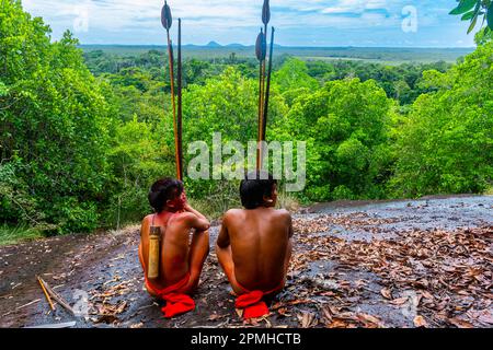 Yanomami-Stammesangehörige sitzen auf einem riesigen Felsen im Dschungel, Süd-Venezuela, Südamerika Stockfoto