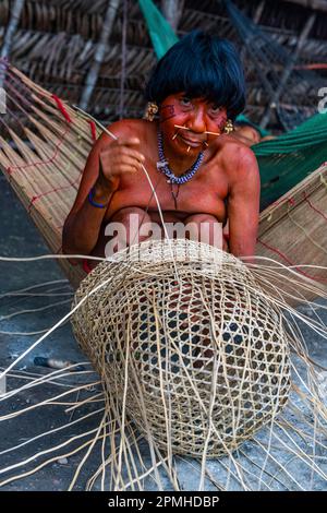 Eine Frau aus dem Yanomami-Stamm, die einen Korb webt, Süd-Venezuela, Südamerika Stockfoto