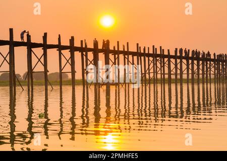 Menschen, die auf der U-Bein Brücke über den Taung Tha man See bei Sonnenuntergang laufen, Amarapura, Mandalay, Myanmar (Birma), Asien Stockfoto