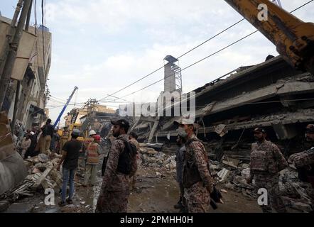 Peshawar, Pakistan, 13. April 2023. Rettungsbeamte sind mit Rettungsarbeiten beschäftigt, nachdem ein Fabrikgebäude während des Kühlprozesses zusammengebrochen ist, nachdem am Donnerstag, den 13. April 2023, ein Brand im Industriegebiet New Karachi in Karatschi ausbrach. Vier Feuerwehrleute starben, während 13 weitere schwere Verletzungen erlitten, nachdem ein Gebäude nach einem massiven Brand in Karatschis Bekleidungsfabrik einstürzte. Laut Medienberichten vor Ort wurde die Fabrik Mittwochabend durch das Feuer gerissen und schließlich im Industriegebiet von Neu-Karatschi zusammengebrochen. Der Vorfall wurde erstmals um 7:53 Uhr gemeldet. Stockfoto