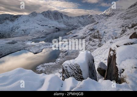 Blick über Cwm Dyli und Llyn Llydaw bis Y Lliwedd und Mount Snowdon (Yr Wyddfa) im Winter, Snowdonia National Park, Eryri, Nordwales, Großbritannien Stockfoto