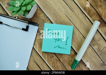 Konzept des Dankeschriebs auf Haftnotizen isoliert auf Holztisch. Stockfoto