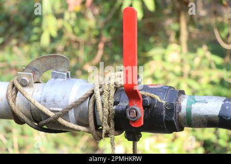 Hochleistungs-Wasserabsperrventil am Wasserleitungsrohr installiert. Kugelhahn mit Gewinde und rotem Griff Stockfoto